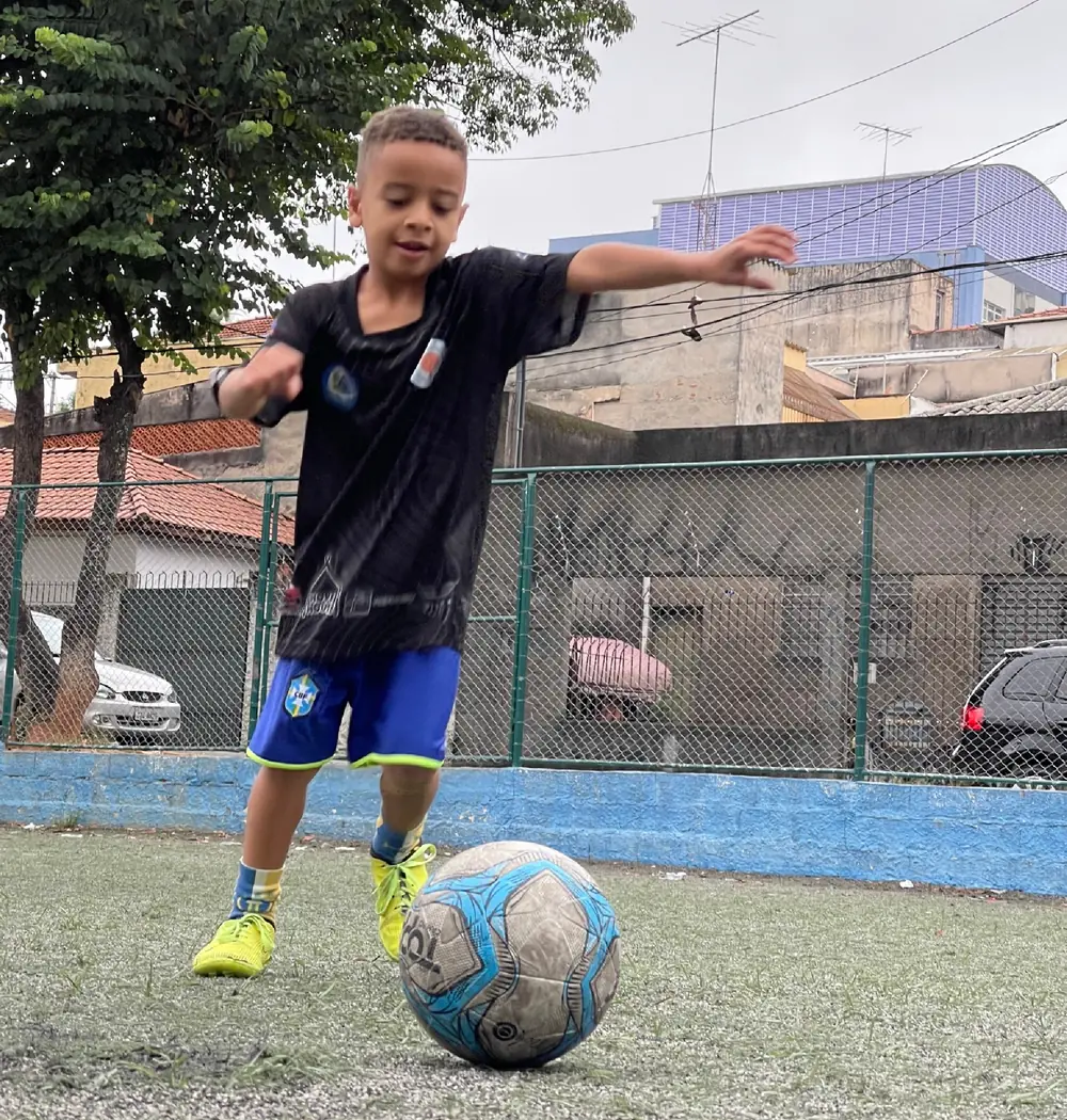 Criança jogando futebol na Hope House